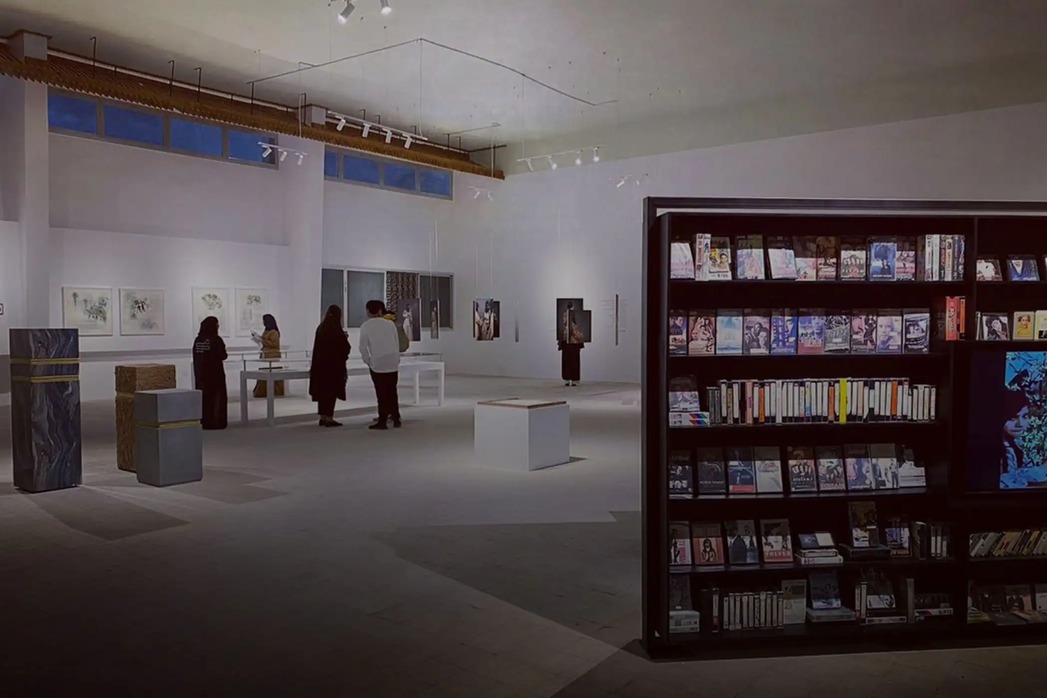 a group of people in a room with books on shelves